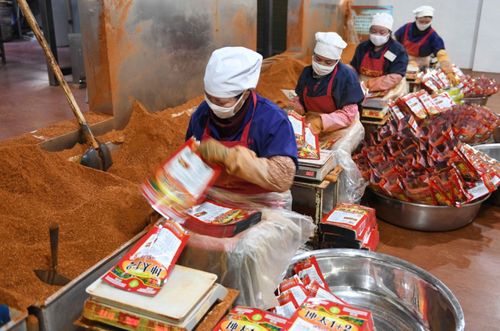 宣威市太坤调味品厂的员工在包装辣椒产品(12月21日摄).